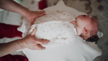 Yetişkinler bebeğin gövdesini ve omuzlarını desteklerken bebek dengeli bir topun üzerine yerleştirildi.