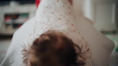 Yetişkinler bebeğin gövdesini ve omuzlarını desteklerken bebek de dengeli bir topun üzerine yerleştirilir.