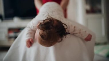 Yetişkinler bebeğin gövdesini ve omuzlarını desteklerken bebek de dengeli bir topun üzerine yerleştirilir.