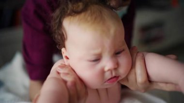 Bakıcı bebekle hareket egzersizi yapıyor.