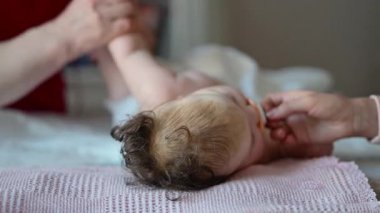 Bakıcı bebekle hareket egzersizi yapıyor.