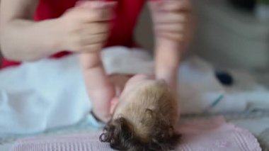 Bakıcı bebekle hareket egzersizi yapıyor.