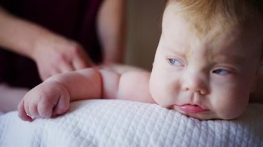 Baby lying on their back while an adult massages them and performs mobility exercises