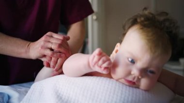 Caregiver doing mobility exercises with a baby