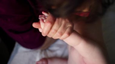 Bakıcı bebekle hareket egzersizi yapıyor.