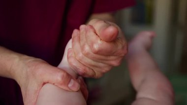 Yetişkinlerin ellerini kapat. Bebeğin ayağına ve tabanına nazikçe masaj yap.