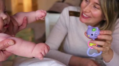 Bebek karnının üstünde yatarken bir yetişkin onlara masaj yapıyor ve hareket egzersizleri yapıyor.