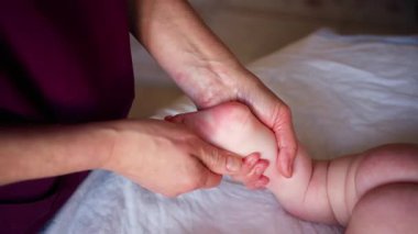 Yetişkinlerin ellerini kapat. Bebeğin ayağına ve tabanına nazikçe masaj yap.