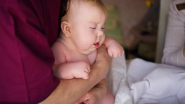 Bakıcı bebekle hareket egzersizi yapıyor.