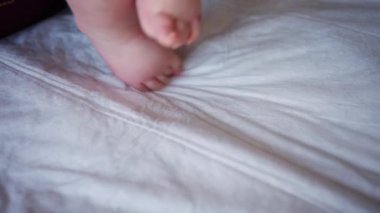 Yetişkinlerin ellerini kapat. Bebeğin ayağına ve tabanına nazikçe masaj yap.