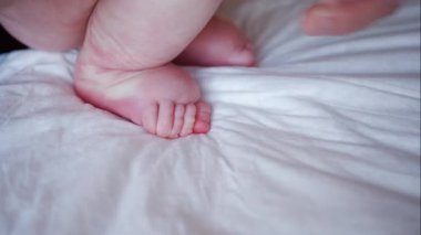 Yetişkinlerin ellerini kapat. Bebeğin ayağına ve tabanına nazikçe masaj yap.