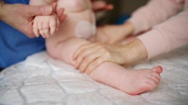 Yetişkinlerin ellerini kapat. Bebeğin ayağına ve tabanına nazikçe masaj yap.