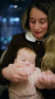 Bir kadının restoranda bebeğini kucağına aldığı sıcak bir an. Dikey