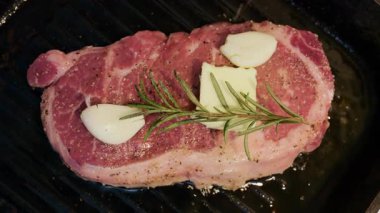 Izgara tavasında pişirirken bifteğe sarımsak ve tereyağı eklendi.