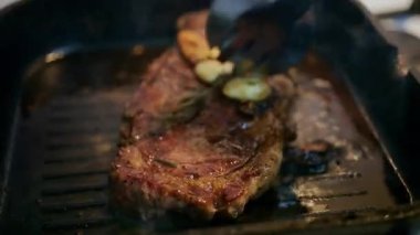 Bir spatulayla ezilirken ızgarada cızırdayan sulu bifteği kapat.