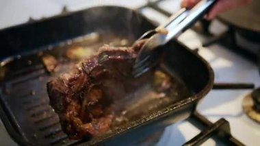 Bir spatulayla ezilirken ızgarada cızırdayan sulu bifteği kapat.