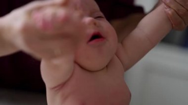 Bakıcı bebekle hareket egzersizi yapıyor.
