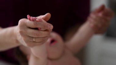 Bakıcı bebekle hareket egzersizi yapıyor.