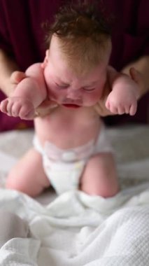 Bakıcı bebekle hareket egzersizi yapıyor.