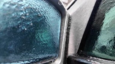 Buz ve erimiş suyla kaplı bir arabanın yan aynasını kapat.