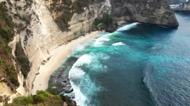 Bali, Nusa Penida 'daki Diamond Beach' in insansız hava aracı görüntüsü. Hint Okyanusu 'ndan gelen turkuaz okyanus dalgaları gibi tenha beyaz kumlu kıyı şeridi dik kireçtaşı uçurumlarının altında kıvrımlar oluşturur.