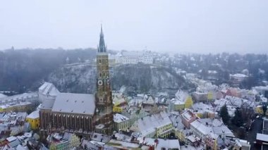 Karla kaplı Landshut Eski Kasabası 'nın insansız hava aracı görüntüsünde St. Martin Kilisesi' nin yüksek Gotik kulesi ve Almanya 'nın Bavyera kentindeki tepedeki Trausnitz Şatosu yer alıyor.