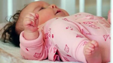 Pembe elbiseli, beşikte uzanmış, huzurlu, uyuyan bir bebeğin fotoğrafını çek.