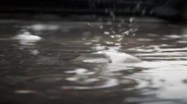 Soyut su yansımaları yumuşak dalgalanmalar ve ışık desenleriyle dokulu bir duvar yüzeyinde hareket ediyor.