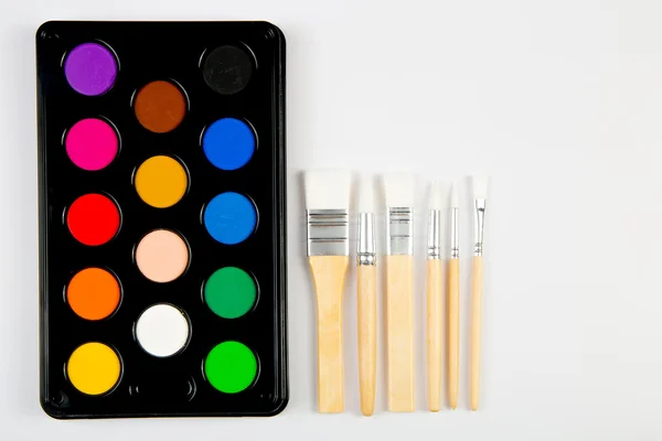 Белые кисти с деревянной ручкой и цветной краской — стоковое фото