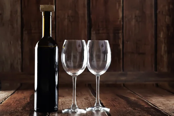 Botella de vino tinto y dos vasos vacíos —  Fotos de Stock