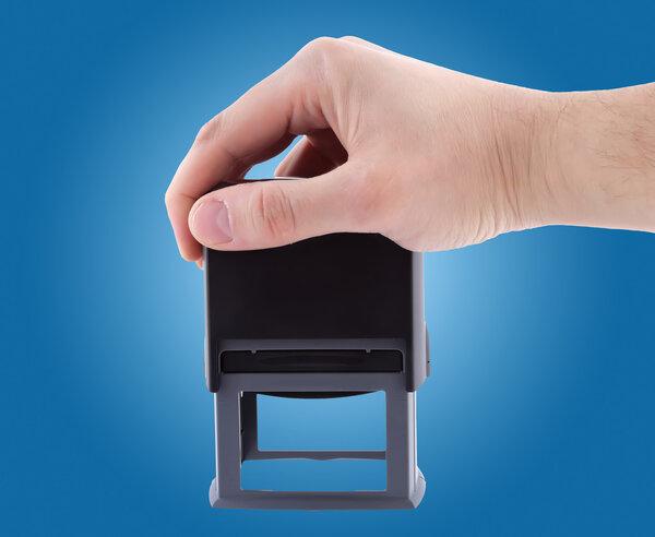 Печать в руках бизнесмена на синем фоне
