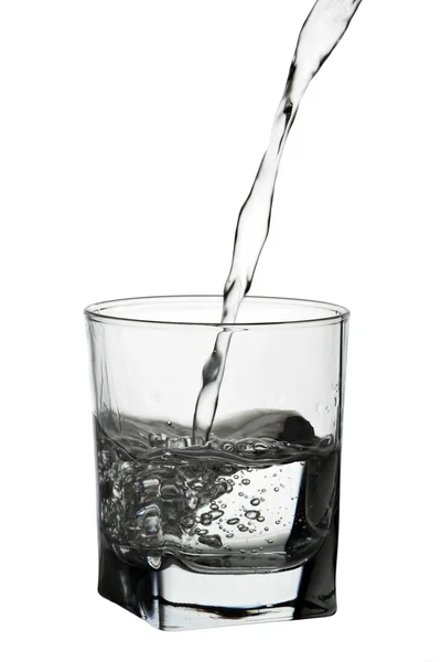Wasser gießt in Glas isoliert auf weiß — Stockfoto
