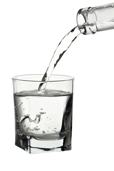 Wasser gießt in transparentes Glas isoliert auf weiß — Stockfoto