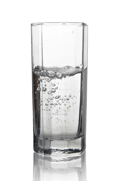 Вода с пузырьками воздуха в высоком стакане с его отражением изола — стоковое фото