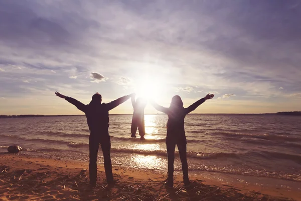 Familia feliz con un bebé al atardecer — Foto de Stock