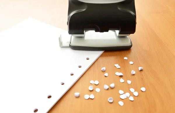 Hole puncher dengan kertas dan confetti di meja kantor — Stok Foto