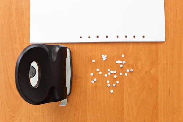 Dziurkacza z papieru i konfetti na stole biurowej — Zdjęcie stockowe