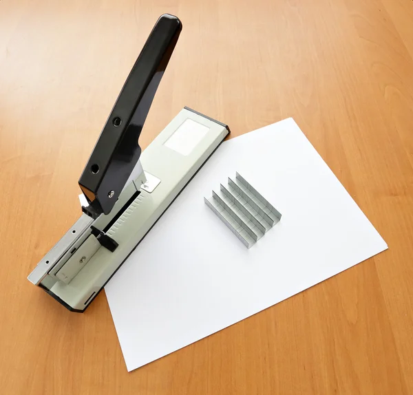 Stapler e graffette con carta sul tavolo — Foto Stock