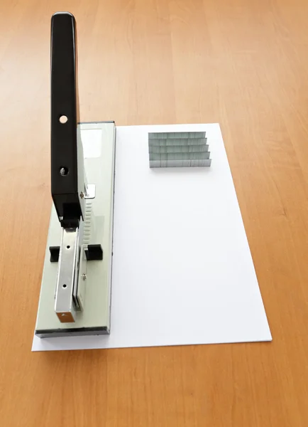 Stapler dan staples dengan kertas di atas meja — Stok Foto