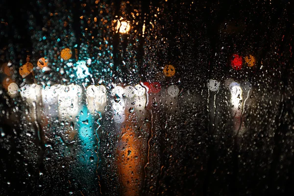 Blurred rain background, view through wet car window — Stock Photo, Image
