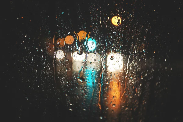 Розмитий фон дощу, вид через вікно мокрого автомобіля — стокове фото