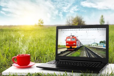 Laptop ve sıcak kahve üzerinde arka plan güzel doğa, açık ofis