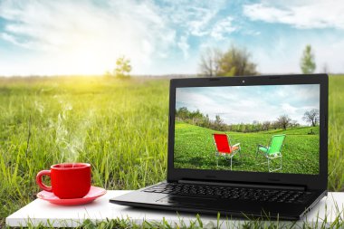 Laptop ve sıcak kahve üzerinde arka plan güzel doğa, açık ofis