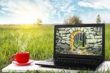 Laptop ve sıcak kahve üzerinde arka plan güzel doğa, açık ofis