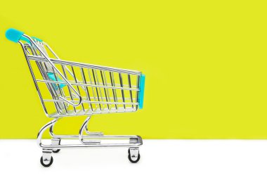 Sarı arka plan üzerinde alışveriş sepeti