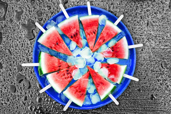 Plátek melounu s kostkami ledu na černém pozadí. Zmrzlina s příchutí melounu — Stock fotografie