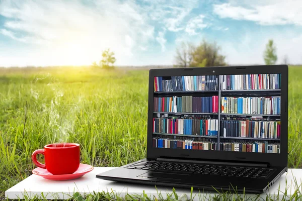 Laptop ve sıcak kahve üzerinde arka plan güzel doğa, açık ofis