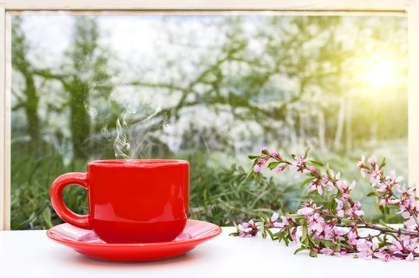 Red hot Cup of coffee on the windowsill