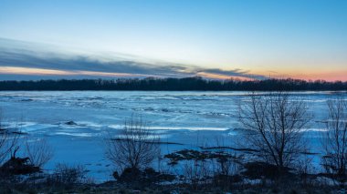 Polonya 'da kış boyunca Vistula nehrinin üzerinde gün batımı