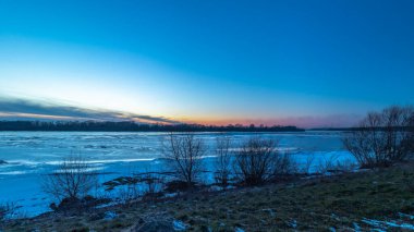 Polonya 'da kış boyunca Vistula nehrinin üzerinde gün batımı